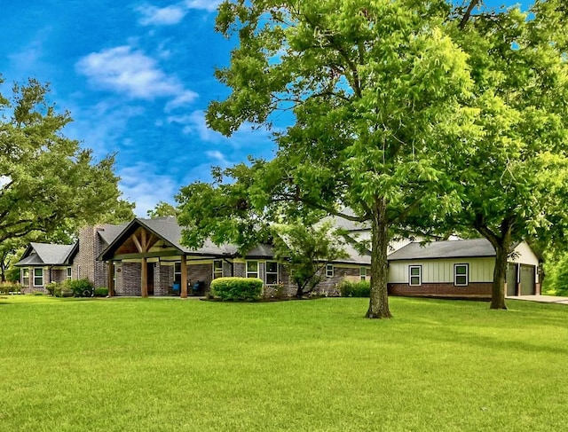7519 Foster Creek Dr, Richmond, TX 77406 - view of front of home with board and batten siding, a front yard, a garage, and brick siding