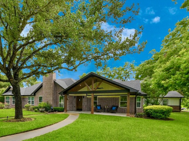 7519 Foster Creek Dr, Richmond, TX 77406 - view of front of house with a front yard, brick siding, a patio, and a ceiling fan