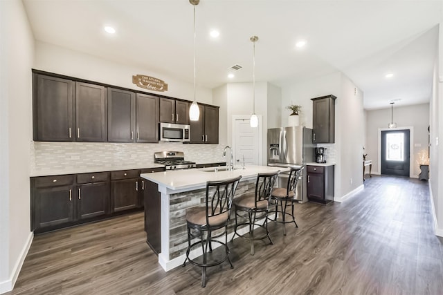 22107 Juniper Crossing Dr, New Caney, TX 77357 - kitchen featuring stainless steel appliances, a sink, backsplash, dark wood-type flooring, and recessed lighting