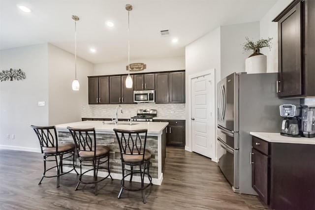 22107 Juniper Crossing Dr, New Caney, TX 77357 - kitchen featuring appliances with stainless steel finishes, a sink, dark wood finished floors, dark brown cabinets, and recessed lighting