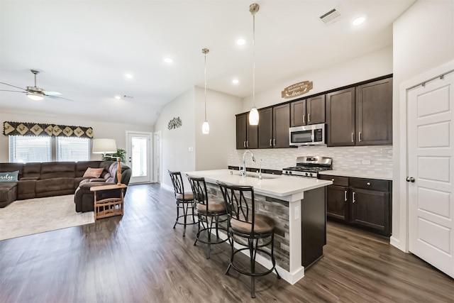 22107 Juniper Crossing Dr, New Caney, TX 77357 - kitchen with stainless steel microwave, gas stove, a sink, backsplash, and vaulted ceiling