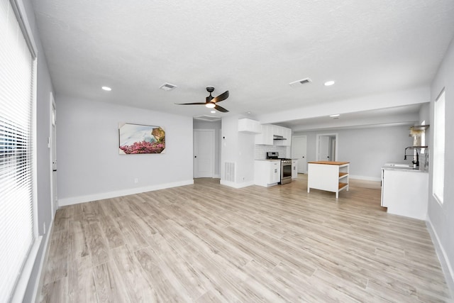 503 Schilling St, Baytown, TX 77520 - unfurnished living room with a sink, a ceiling fan, baseboards, recessed lighting, and light wood-style flooring