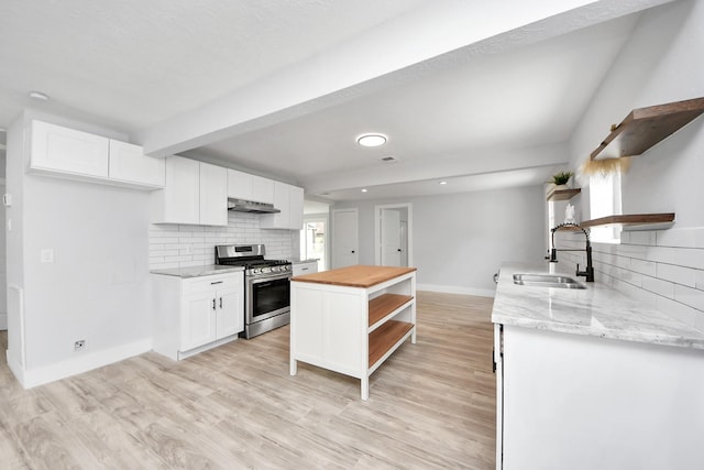 503 Schilling St, Baytown, TX 77520 - kitchen with open shelves, stainless steel range with gas stovetop, wood counters, under cabinet range hood, and a sink