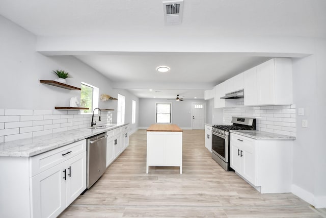 503 Schilling St, Baytown, TX 77520 - kitchen featuring stainless steel appliances, open shelves, a sink, under cabinet range hood, and tasteful backsplash