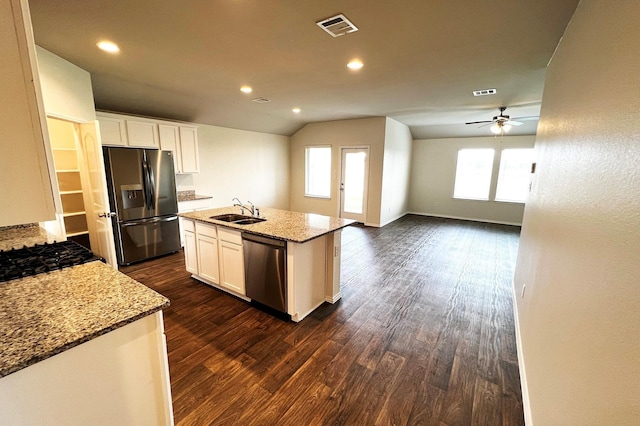 22911 San Giorgio Ct, Katy, TX 77449 - kitchen with stainless steel appliances, dark wood-style flooring, a sink, white cabinets, and lofted ceiling