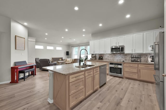 9203 White Tail Dr, Conroe, TX 77303 - kitchen featuring appliances with stainless steel finishes, light wood-style flooring, recessed lighting, open floor plan, and backsplash