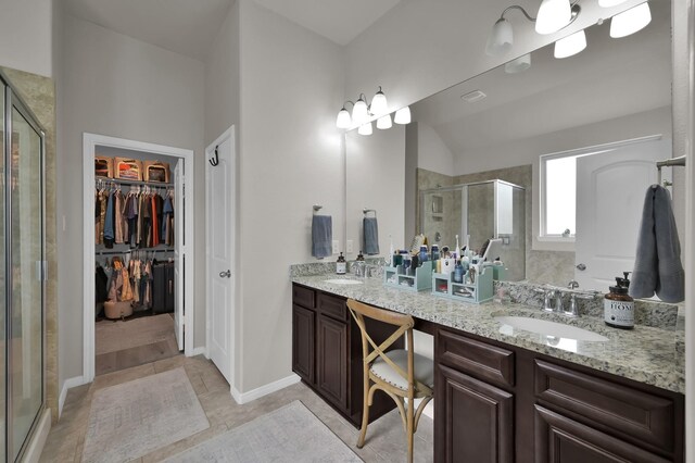9203 White Tail Dr, Conroe, TX 77303 - bathroom featuring a shower stall, double vanity, a spacious closet, and tile patterned flooring