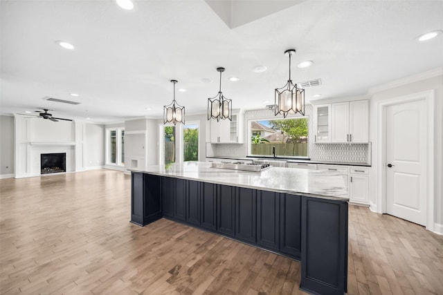 17511 Cassina Dr, Spring, TX 77388 - kitchen with decorative backsplash, a large island, white cabinetry, ornamental molding, and recessed lighting