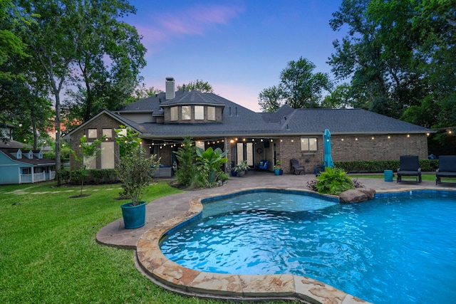 72 Tall Trl, Missouri City, TX 77459 - pool at dusk featuring a patio area, a yard, and an outdoor pool