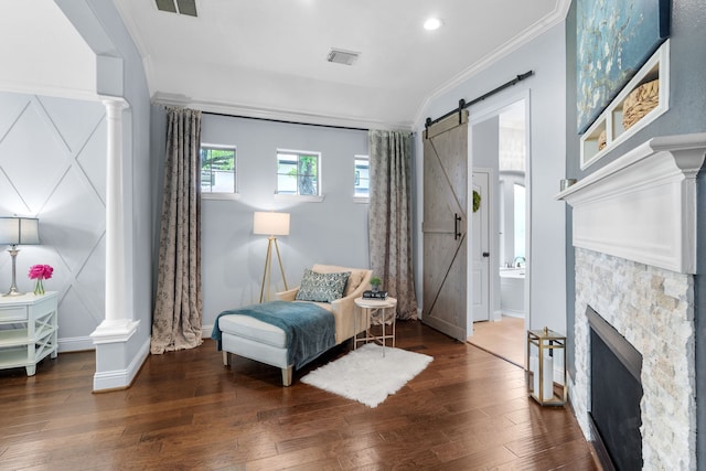 72 Tall Trl, Missouri City, TX 77459 - living area featuring a barn door, ornate columns, wood-type flooring, crown molding, and baseboards