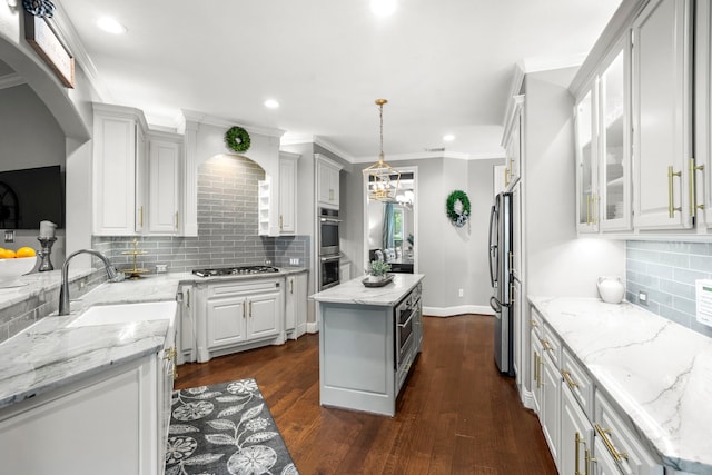 72 Tall Trl, Missouri City, TX 77459 - kitchen featuring appliances with stainless steel finishes, decorative backsplash, white cabinets, light stone counters, and dark wood finished floors