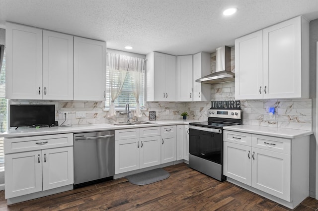 20407 Spoonwood Dr, Humble, TX 77346 - kitchen featuring stainless steel appliances, wall chimney exhaust hood, a sink, white cabinets, and a textured ceiling