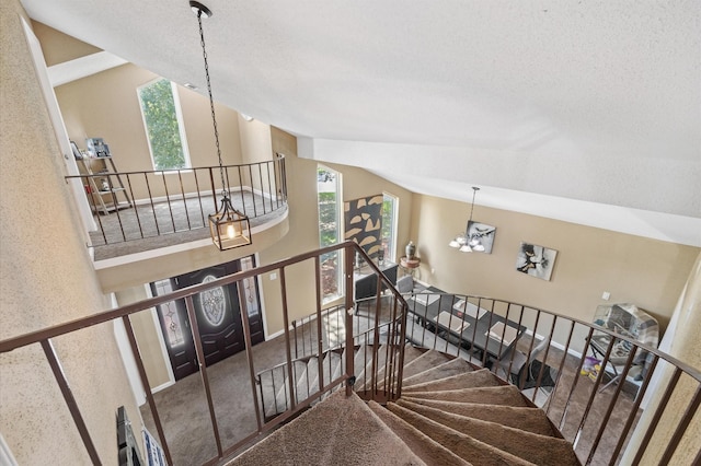 20407 Spoonwood Dr, Humble, TX 77346 - stairs featuring a chandelier, vaulted ceiling, carpet floors, and a textured ceiling