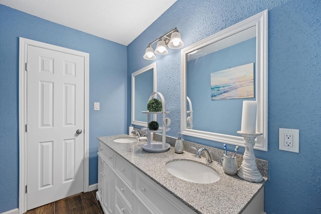 20407 Spoonwood Dr, Humble, TX 77346 - full bathroom featuring double vanity, a textured wall, and wood finished floors