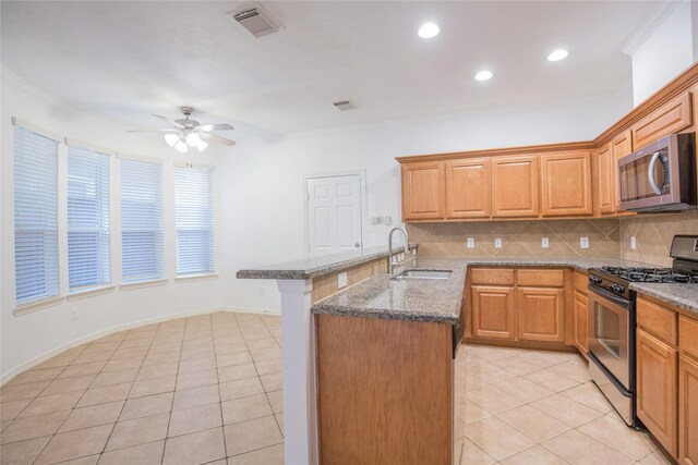 5413 Kiam St Unit B, Houston, TX 77007 - kitchen featuring appliances with stainless steel finishes, a sink, a peninsula, ceiling fan, and decorative backsplash