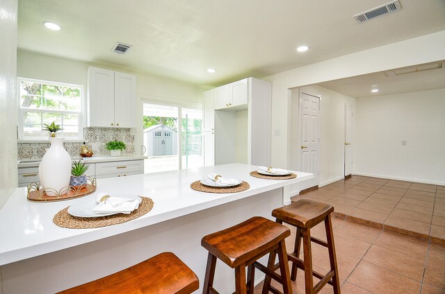 14934 Arundel Dr, Channelview, TX 77530 - kitchen featuring a breakfast bar, healthy amount of natural light, light tile patterned floors, light countertops, and recessed lighting