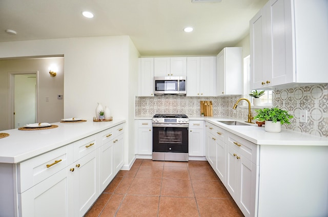 14934 Arundel Dr, Channelview, TX 77530 - kitchen with stainless steel appliances, a sink, a peninsula, backsplash, and light countertops