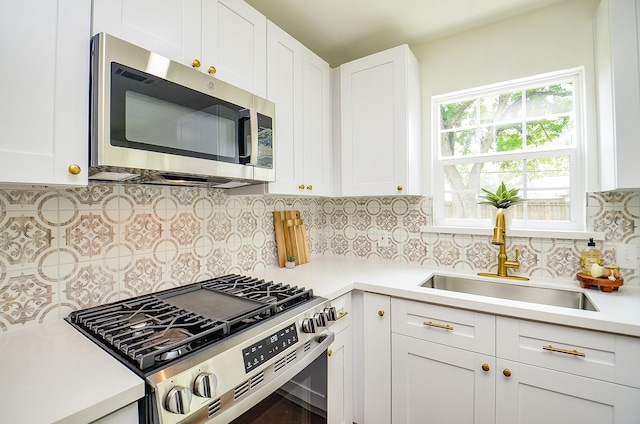 14934 Arundel Dr, Channelview, TX 77530 - kitchen with stainless steel appliances, a sink, light countertops, decorative backsplash, and white cabinetry