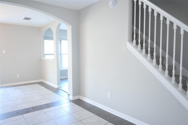 12002 Cobbs Creek Ct, Houston, TX 77067 - empty room featuring tile patterned floors, a smoke detector, arched walkways, and baseboards