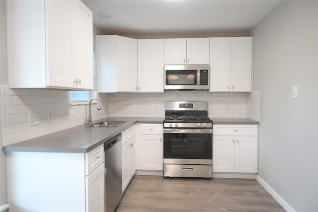 12002 Cobbs Creek Ct, Houston, TX 77067 - kitchen featuring appliances with stainless steel finishes, a sink, white cabinets, and light wood-style flooring