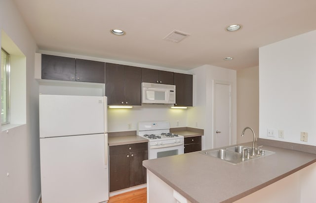 1508 Cleveland St, Houston, TX 77019 - kitchen featuring white appliances, a sink, a peninsula, recessed lighting, and dark brown cabinets