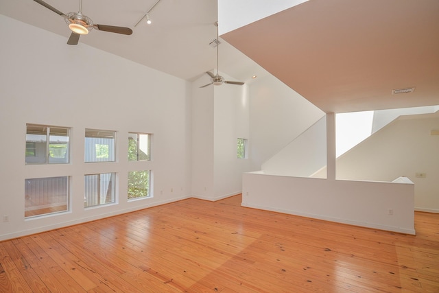 1508 Cleveland St, Houston, TX 77019 - unfurnished living room featuring ceiling fan, high vaulted ceiling, rail lighting, baseboards, and light wood-type flooring