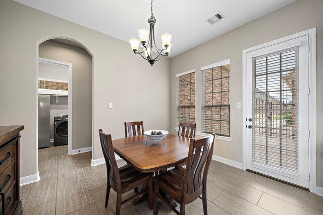 2506 Haven Hill Dr, Katy, TX 77494 - dining room featuring washer / clothes dryer, a chandelier, arched walkways, and baseboards