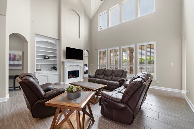 2506 Haven Hill Dr, Katy, TX 77494 - living area featuring high vaulted ceiling, built in features, baseboards, and healthy amount of natural light