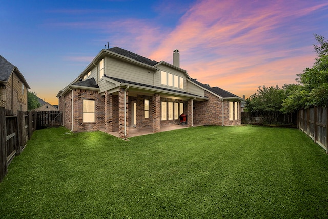 2506 Haven Hill Dr, Katy, TX 77494 - back of house at dusk with a chimney, a patio, and brick siding