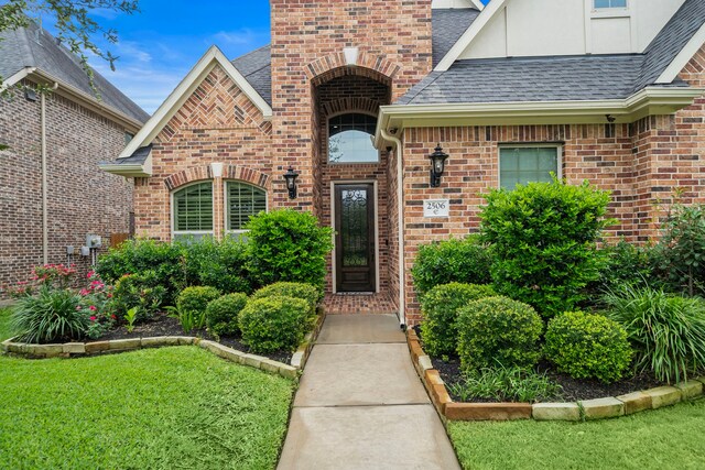 2506 Haven Hill Dr, Katy, TX 77494 - property entrance with brick siding, a shingled roof, and a lawn