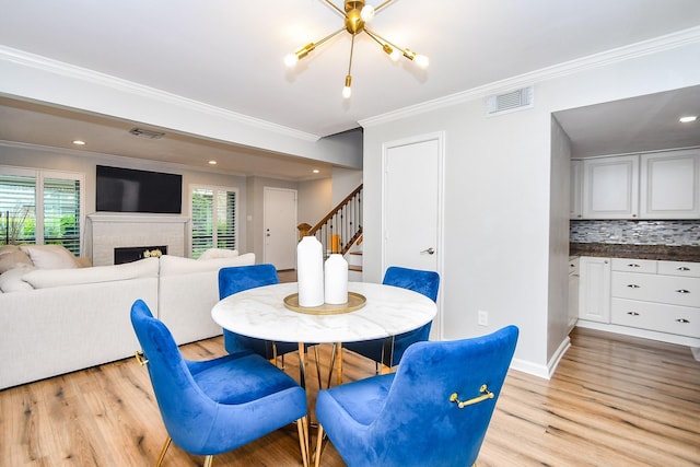 1908 Augusta Dr Unit 10, Houston, TX 77057 - dining room with stairs, crown molding, light wood-style flooring, a fireplace, and baseboards