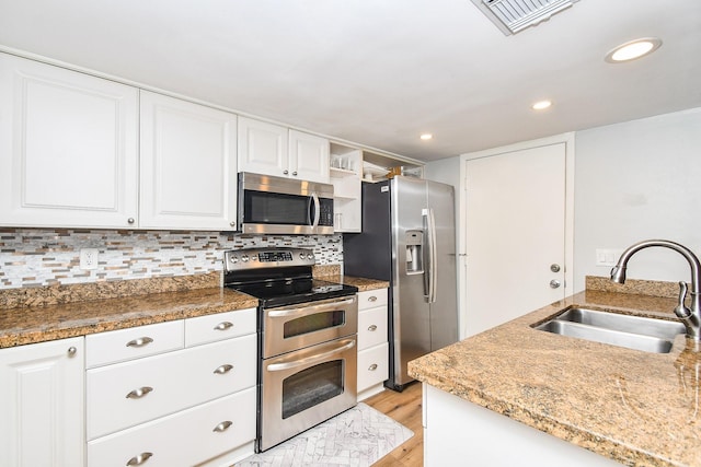 1908 Augusta Dr Unit 10, Houston, TX 77057 - kitchen with stainless steel appliances, a sink, light wood-style floors, white cabinetry, and tasteful backsplash