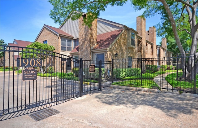 1908 Augusta Dr Unit 10, Houston, TX 77057 - view of front facade with brick siding, a gate, and a chimney