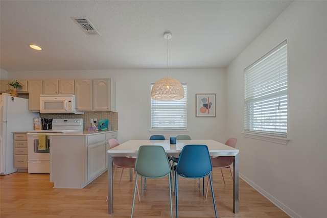 22023 Deaf P Smith Dr, Galveston, TX 77554 - kitchen with white appliances, plenty of natural light, a peninsula, light wood-type flooring, and recessed lighting