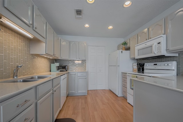22023 Deaf P Smith Dr, Galveston, TX 77554 - kitchen with white appliances, light wood-style flooring, tasteful backsplash, light countertops, and recessed lighting