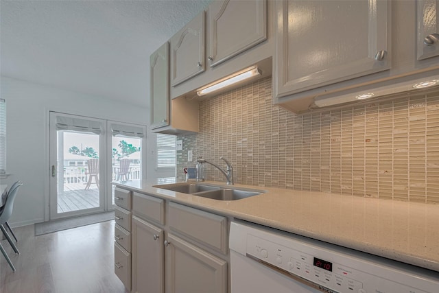 22023 Deaf P Smith Dr, Galveston, TX 77554 - kitchen featuring dishwasher, light countertops, tasteful backsplash, wood finished floors, and white cabinetry