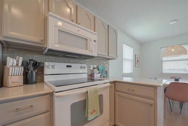 22023 Deaf P Smith Dr, Galveston, TX 77554 - kitchen with white appliances, light countertops, tasteful backsplash, a peninsula, and hanging light fixtures
