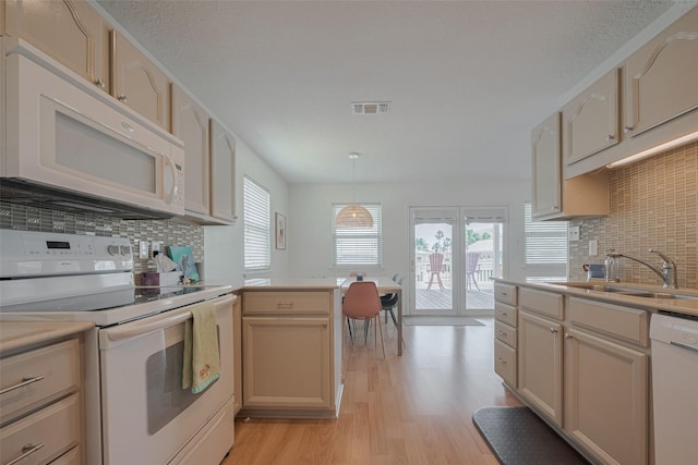 22023 Deaf P Smith Dr, Galveston, TX 77554 - kitchen featuring white appliances, light wood-style floors, decorative backsplash, light countertops, and a peninsula
