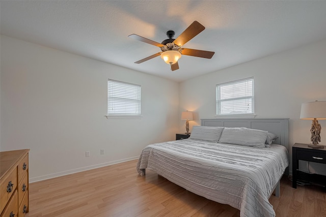 22023 Deaf P Smith Dr, Galveston, TX 77554 - bedroom with multiple windows, light wood-style floors, and ceiling fan