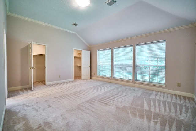 5022 Moss Run Dr, Missouri City, TX 77459 - unfurnished bedroom featuring crown molding, baseboards, a spacious closet, vaulted ceiling, and carpet floors