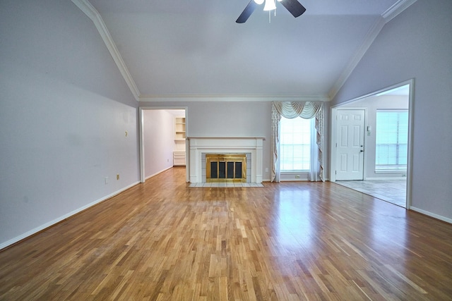 5022 Moss Run Dr, Missouri City, TX 77459 - unfurnished living room featuring vaulted ceiling, ornamental molding, a ceiling fan, wood finished floors, and a tiled fireplace