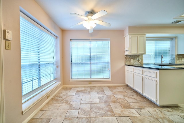 5022 Moss Run Dr, Missouri City, TX 77459 - kitchen featuring ceiling fan, dark countertops, backsplash, white cabinetry, and baseboards