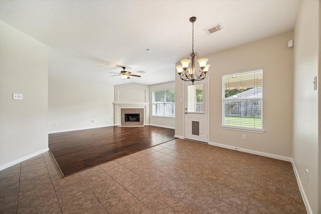 5023 Birch Manor Ln, Katy, TX 77494 - unfurnished living room featuring dark tile patterned flooring, ceiling fan, a chandelier, a fireplace with flush hearth, and baseboards