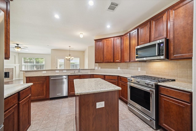 5023 Birch Manor Ln, Katy, TX 77494 - kitchen featuring stainless steel appliances, a sink, a peninsula, decorative backsplash, and ceiling fan