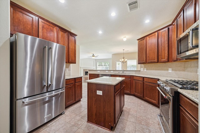 5023 Birch Manor Ln, Katy, TX 77494 - kitchen featuring high end appliances, a sink, a peninsula, light stone countertops, and a ceiling fan