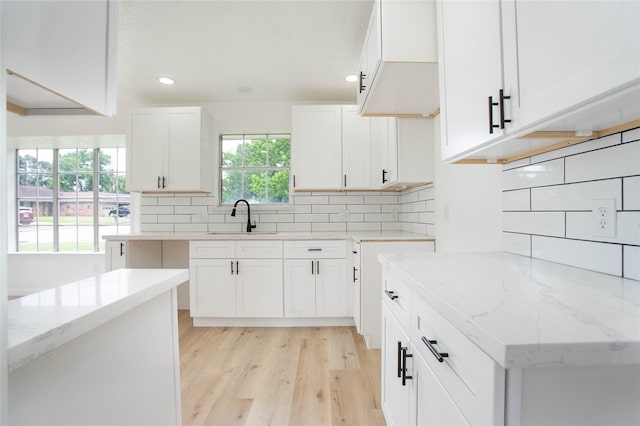 29302 Raestone St, Spring, TX 77386 - kitchen with a sink, backsplash, light wood-style floors, light stone counters, and recessed lighting