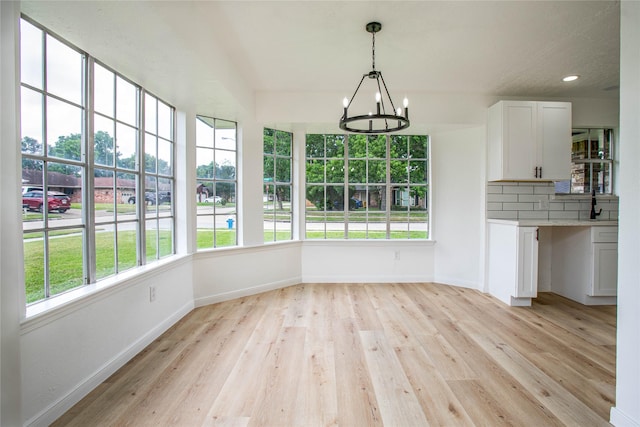 29302 Raestone St, Spring, TX 77386 - unfurnished dining area with a chandelier, light wood-style floors, baseboards, and recessed lighting