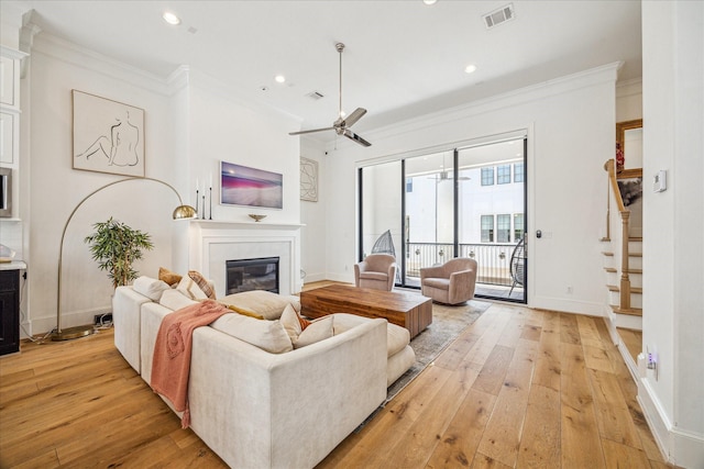 6110 Nicholas Grove Pl, Houston, TX 77055 - living room with a glass covered fireplace, light wood-style flooring, baseboards, crown molding, and ceiling fan