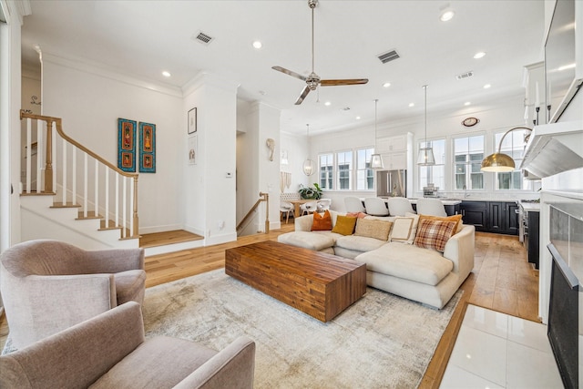 6110 Nicholas Grove Pl, Houston, TX 77055 - living area featuring a ceiling fan, crown molding, stairs, recessed lighting, and light wood-type flooring