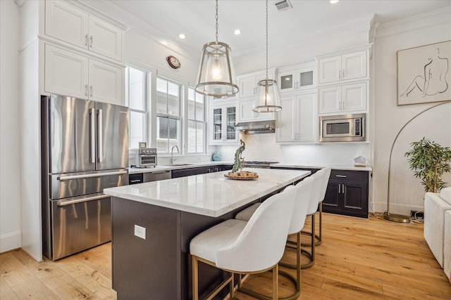 6110 Nicholas Grove Pl, Houston, TX 77055 - kitchen featuring appliances with stainless steel finishes, white cabinetry, light wood-type flooring, ornamental molding, and recessed lighting